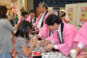 もっと食べよう岡山米「きぬむすめ祭」において知事が来場者へ米の試食を渡す様子