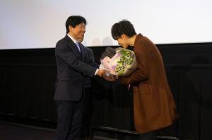 映画「８年越しの花嫁」初日舞台挨拶で主演の佐藤健さんに花束を渡す知事の写真