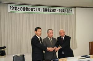 調印後の握手（左から石垣市長、藤井社長、中島森林組合長）