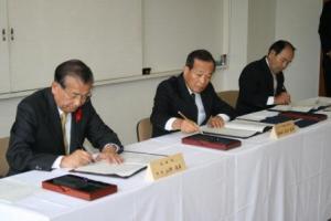 協定書に調印する山野町長（左）、高月専務取締役（中）、岡田森林組合長