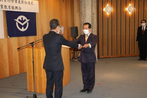 ▲服部恭一郎会長（写真左）から表彰状を受け取る岡田哲朗校長（県立岡山東商業高等学校）