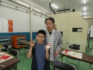 完成した文鎮を持って喜んでいる親子の写真