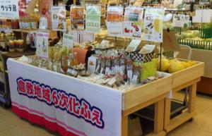 倉敷地域６次化ふぇの垂幕が掲げられており、机上に商品が並ぶ様子