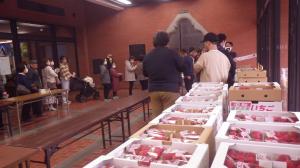 生産者が購入者にいちごを渡す様子