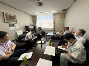 卸業者と生産者が会議室で情報交換している写真