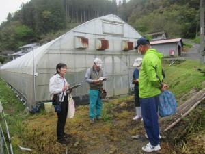 普及指導員がクレマチスハウスの前で参加者に栽培について説明しています